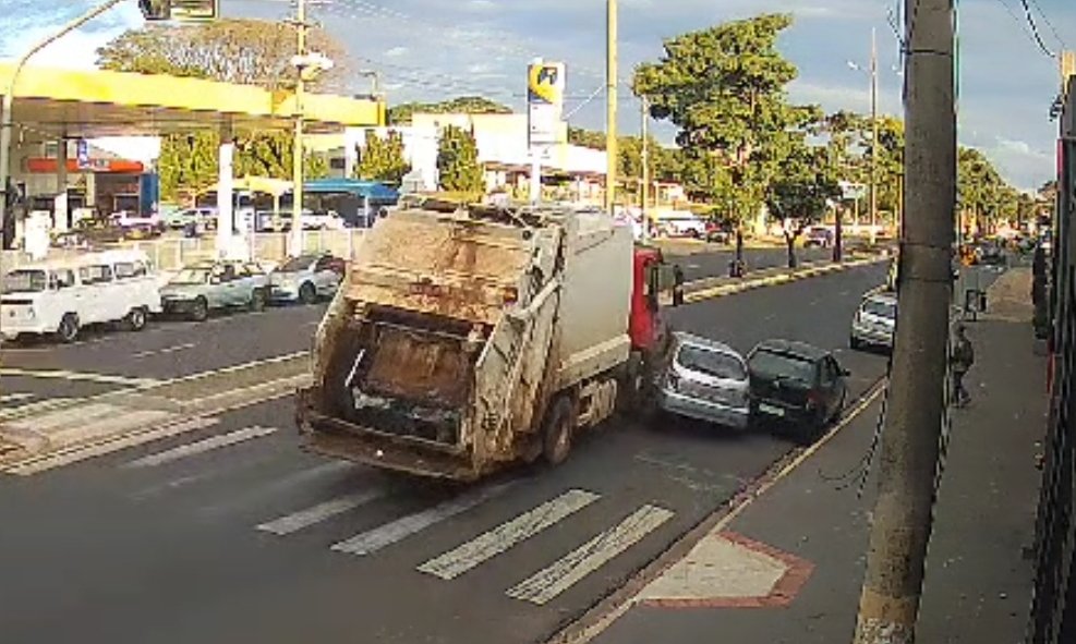 Caminhão de lixo colide contra carro e atinge pedestre na calçada